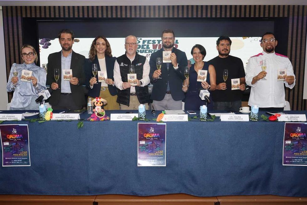 Nueve participantes en la presentaci\u00f3n del Festival del Vino Queretano 2026 brindan con copas frente a la pantalla con el cartel de la sexta edici\u00f3n.