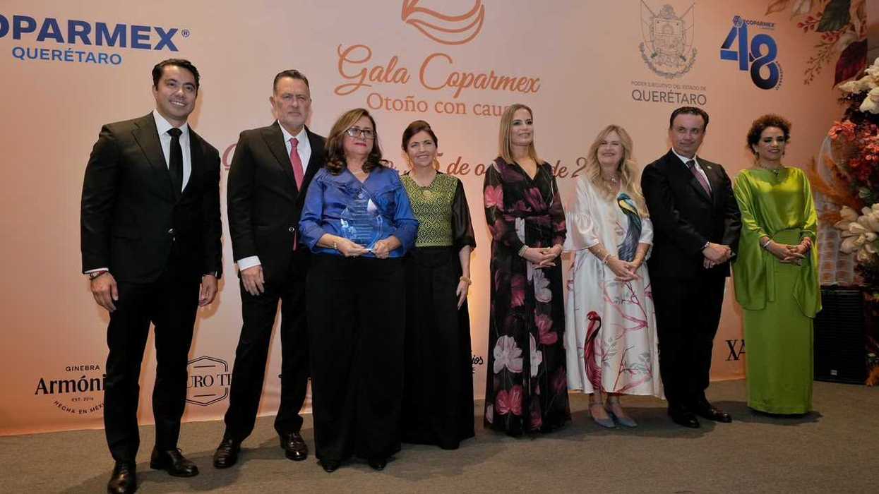 Ocho personas posan ante el fondo de la Gala COPARMEX Otoño con Causa; una mujer sostiene un reconocimiento de cristal