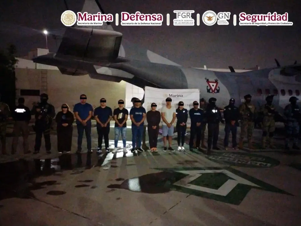 Ocho presuntos integrantes del CJNG detenidos frente a inmueble urbano custodiados por elementos de corporaciones federales.