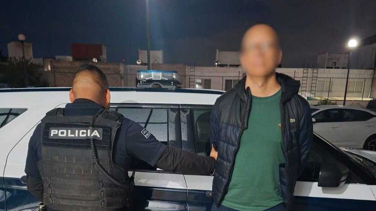 Oficial de la Policía Municipal de Querétaro custodia junto a una patrulla a un hombre detenido por robo a comercio en El Jacal.