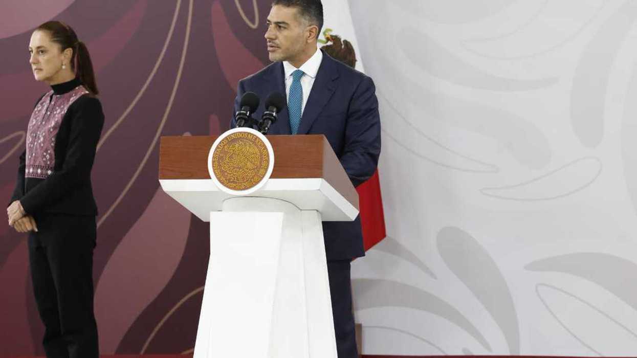 Omar García Harfuch, secretario de Seguridad y Protección Ciudadana, habla en un podio durante un evento oficial, con la presidenta Claudia Sheinbaum al fondo