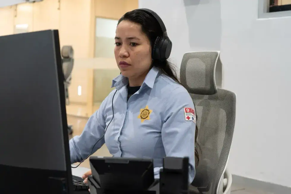 Operadora del 9-1-1 de Quer\u00e9taro con aud\u00edfonos frente a monitor