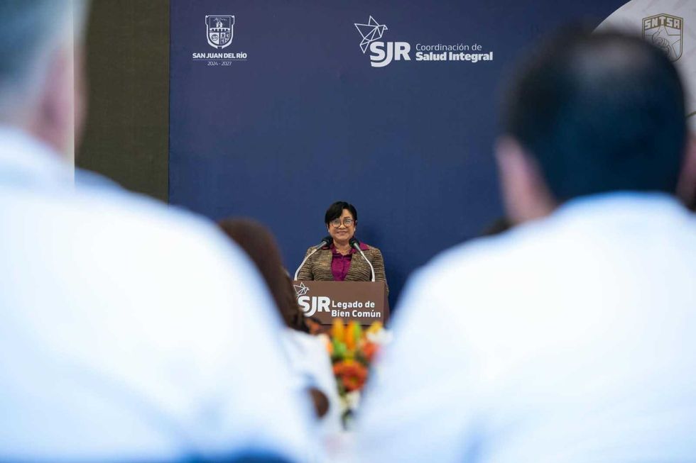 Oradora en el atril durante la ceremonia del Distintivo al M\u00e9rito en Medicina 2026 en San Juan del R\u00edo