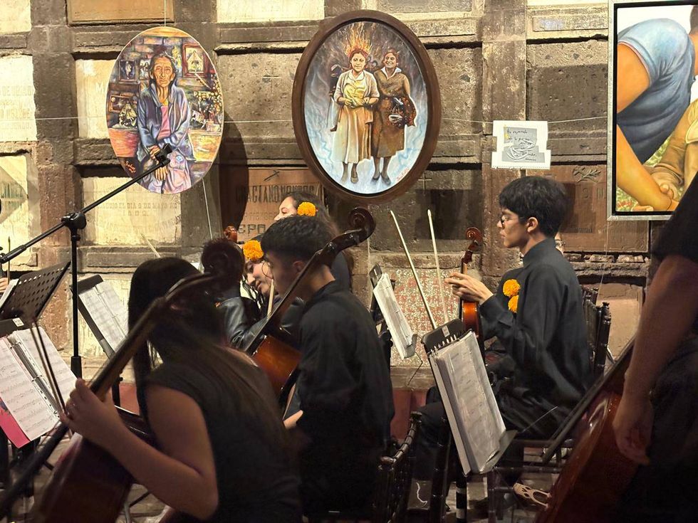 Orquesta Comunitaria de Cuerdas con cempas\u00fachil en el cabello en el Concierto para las \u00c1nimas del Museo de la Muerte