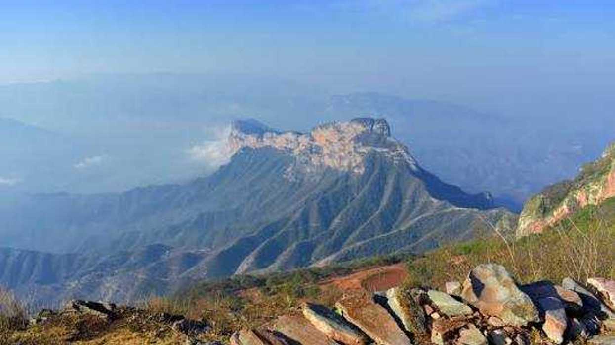 Paisaje serrano de Pinal de Amoles con montañas y un peñasco rocoso visto desde una cumbre con piedras al frente