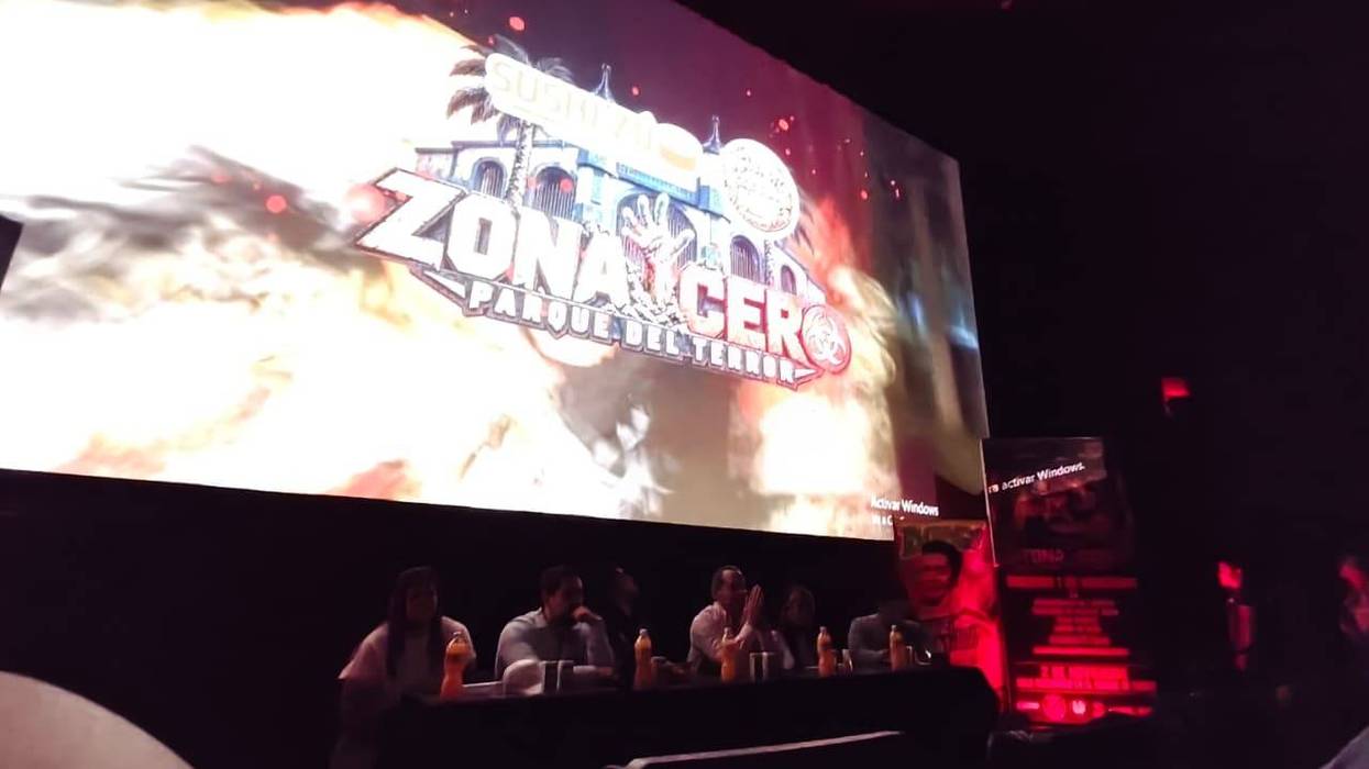 Pantalla con el logotipo de Zona Cero Parque del Terror frente a la mesa de la presentación