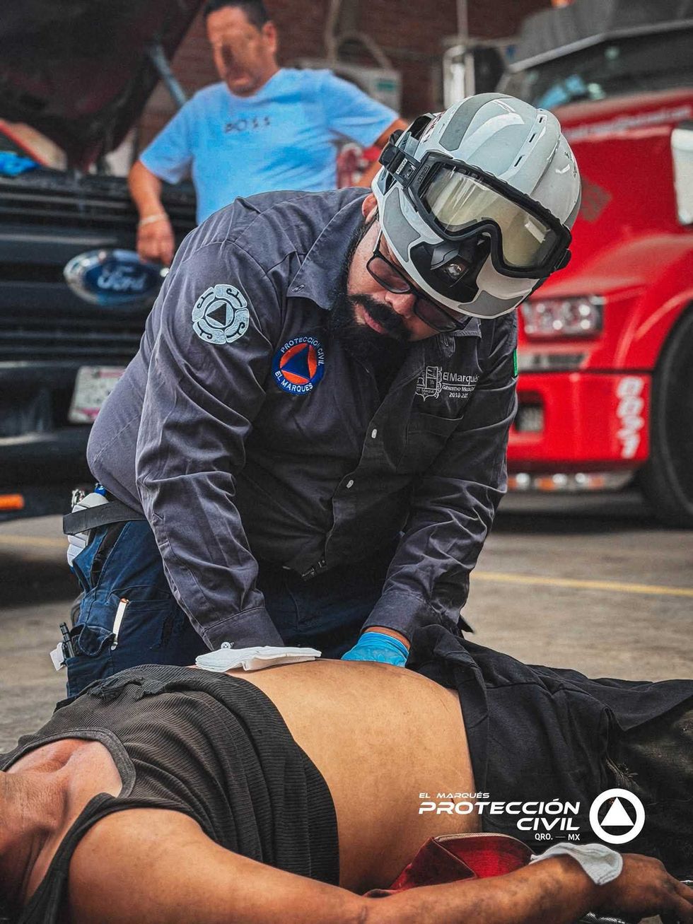 Param\u00e9dico de Protecci\u00f3n Civil El Marqu\u00e9s atiende a hombre lesionado tendido en el piso de un taller mec\u00e1nico en La Griega