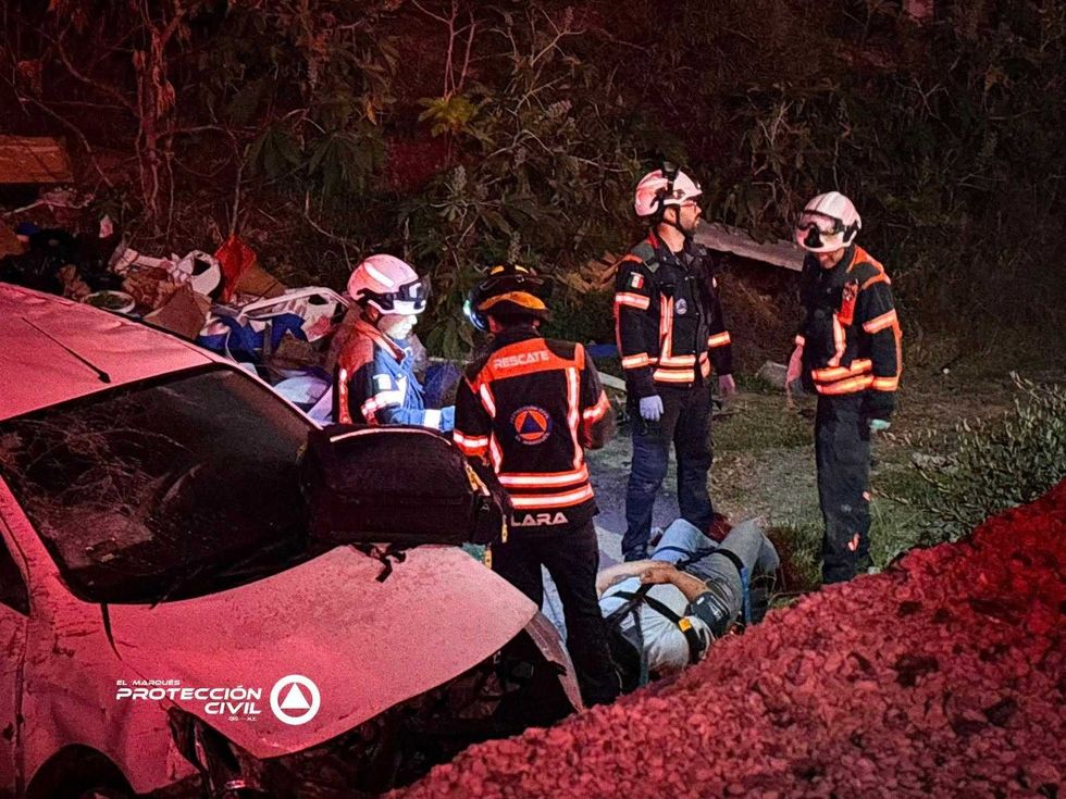 Param\u00e9dicos y rescatistas de Protecci\u00f3n Civil asisten a una persona lesionada junto a un veh\u00edculo accidentado en una zanja.