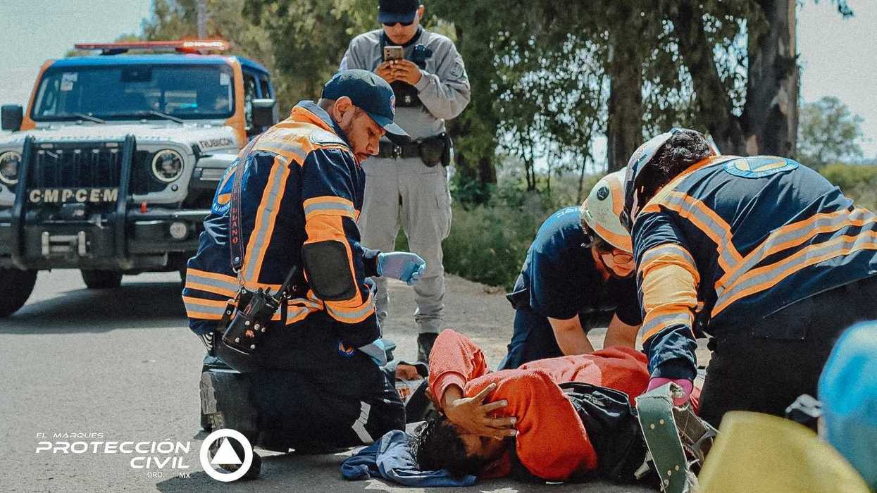 Paramédicos de Protección Civil El Marqués atienden en el piso a un trabajador lesionado en Guadalupe La Venta.