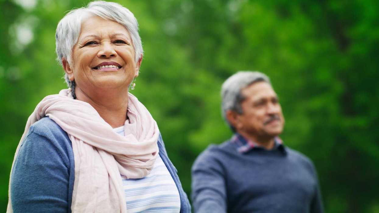 Pareja de personas adultas mayores sonríe al aire libre, imagen ilustrativa sobre envejecimiento saludable.