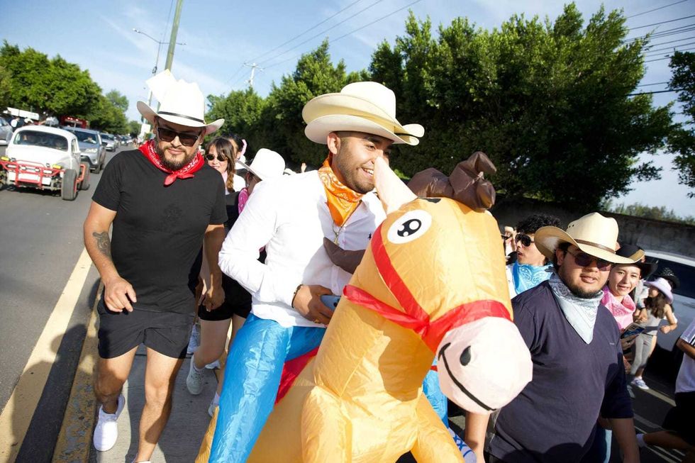 Participante disfrazado con caballo inflable y sombrero vaquero durante la carrera FestiVaqueRun 2026 en San Juan del R\u00edo
