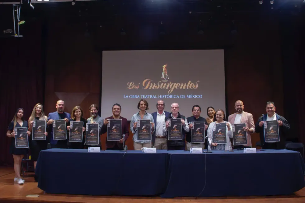Participantes en la presentaci\u00f3n de "Los Insurgentes" muestran el cartel de la obra en Quer\u00e9taro 2026