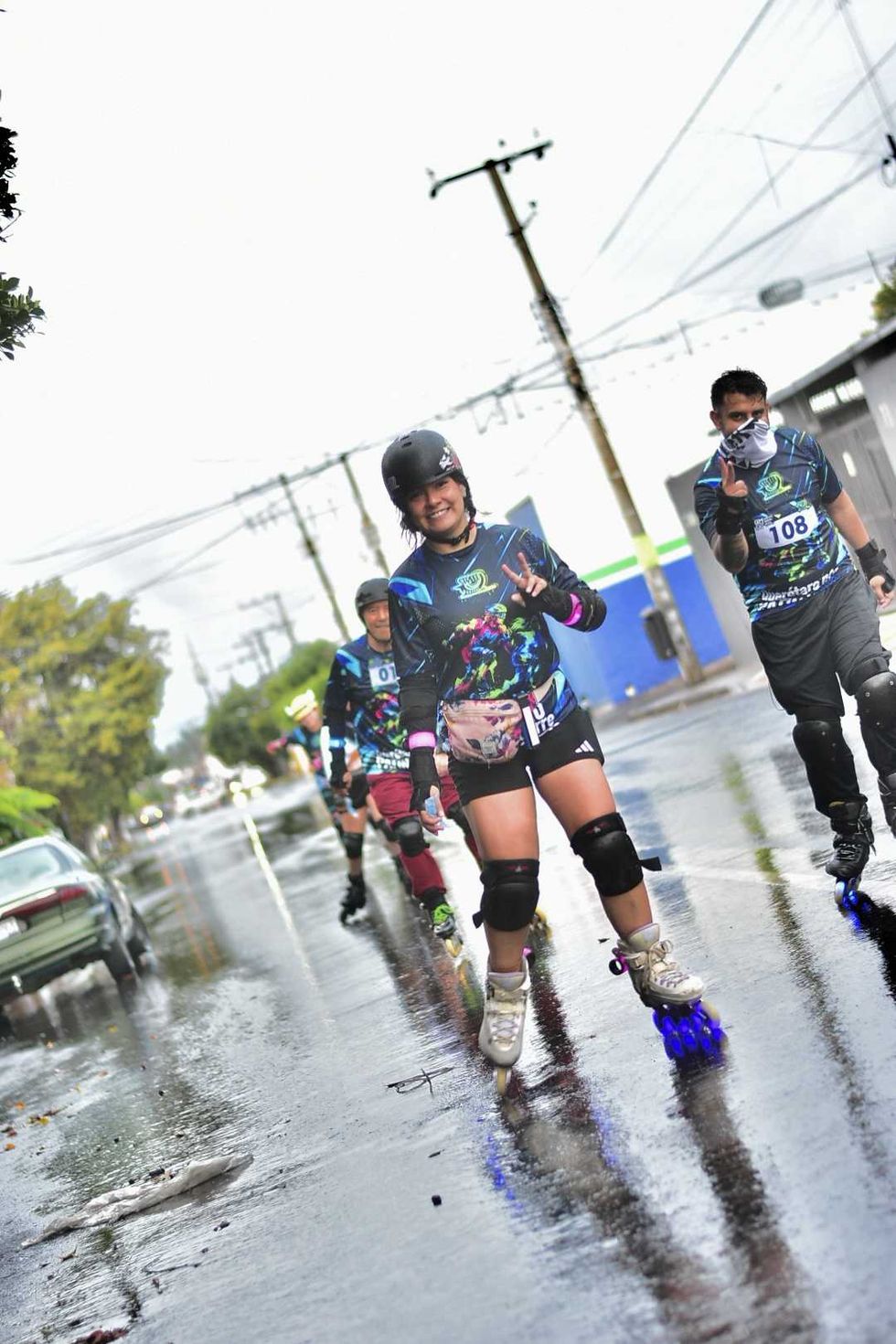 Patinadora sonr\u00ede y hace la se\u00f1al de amor y paz junto a otros competidores con n\u00famero en el Quer\u00e9taro Marat\u00f3n Roller 2026
