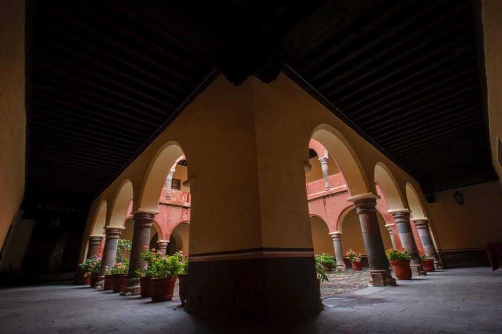 Patio con arcos de cantera, columnas y macetas con flores en un edificio de Tlaxcala, ciudad que cumple 501 a\u00f1os de fundaci\u00f3n