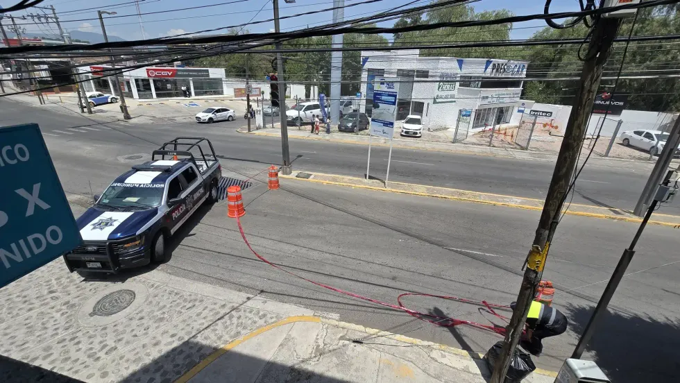 Patrulla de la Polic\u00eda Municipal resguarda la intersecci\u00f3n de Boulevard Hidalgo con conos y cinta de peligro durante trabajos de bacheo en San Juan del R\u00edo.