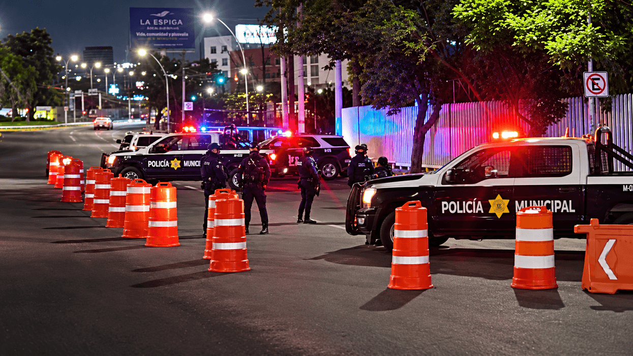 Patrulla de la Policía Municipal con la leyenda Alcoholímetro Municipal junto a conos naranjas sobre una avenida, de noche