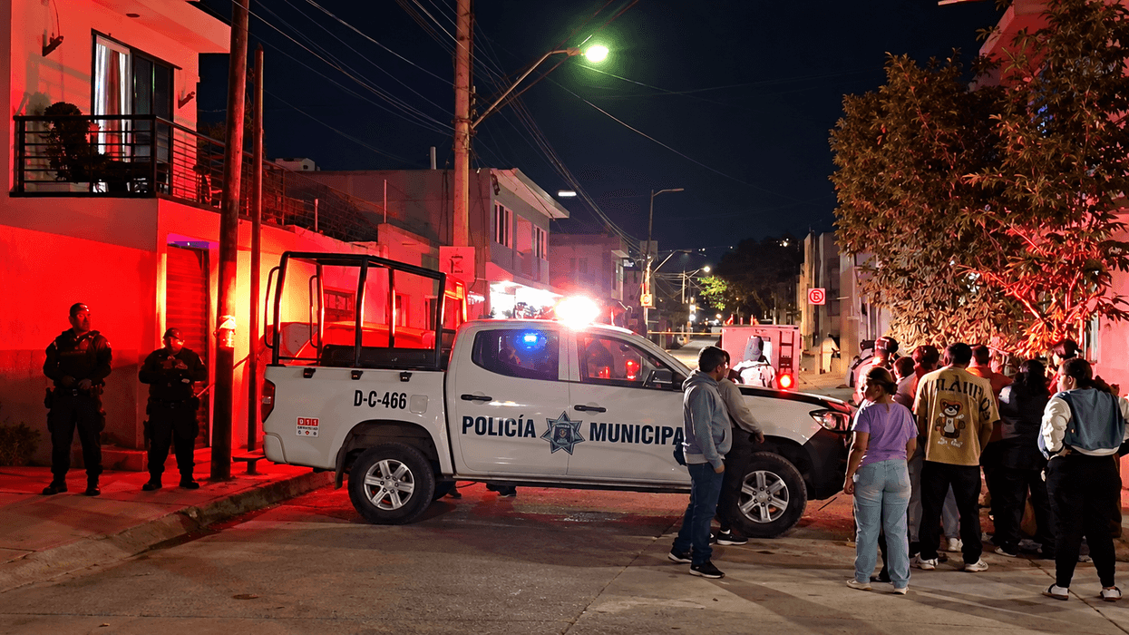 Patrulla de la Policía Municipal y agentes resguardan una calle de la colonia Valle de San Bernardo, en León, mientras vecinos se reúnen tras un ataque armado