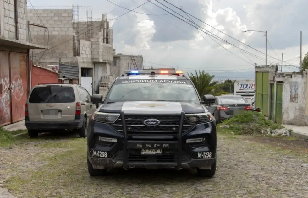 Patrulla M-1238 de la SSPMQ con torretas encendidas en calle empedrada de colonias del norponiente de Quer\u00e9taro, primer semestre 2026