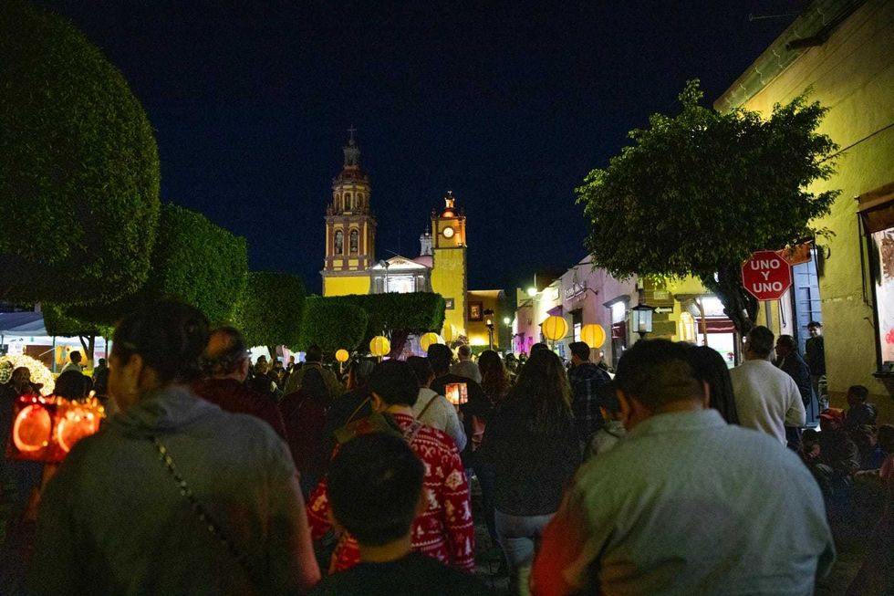 Peregrinos portan farolitos en avenida Ju\u00e1rez de San Juan del R\u00edo durante la procesi\u00f3n a la Virgen de Guadalupe.