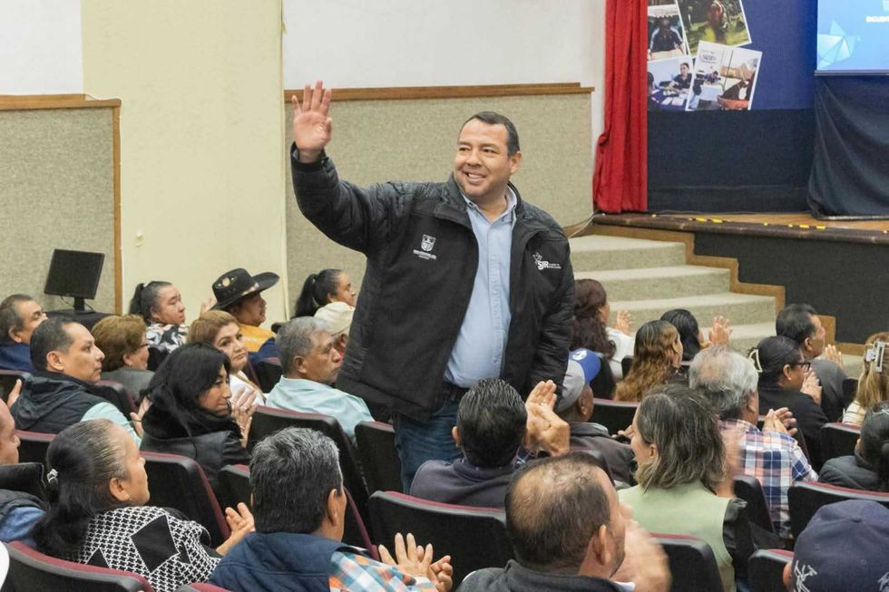 Persona de pie saluda al p\u00fablico durante el encuentro del Quinto Informe de Gobierno en San Juan del R\u00edo