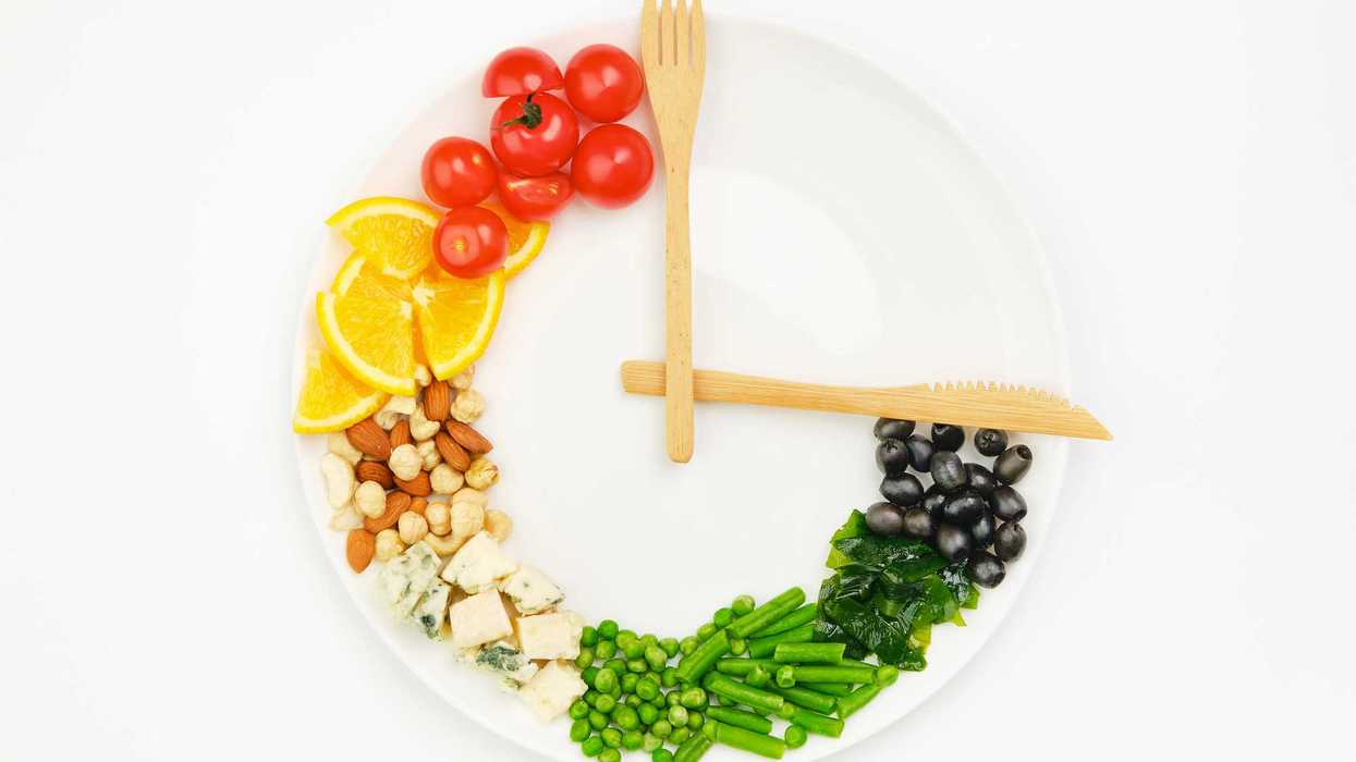 Persona practicando ayuno intermitente con alimentos saludables y un reloj que representa la ventana de alimentación de 16 horas.