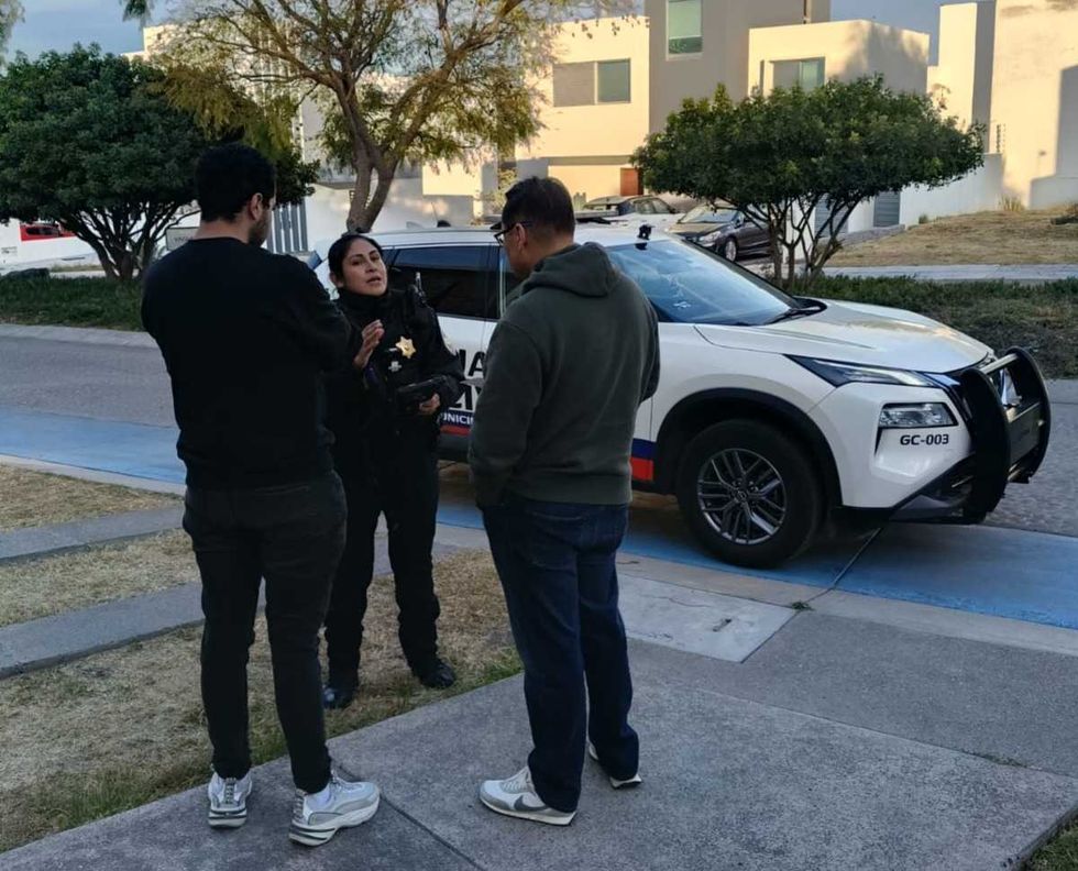 Persona realizando trabajo comunitario de limpieza en espacio p\u00fablico de Quer\u00e9taro bajo supervisi\u00f3n policial