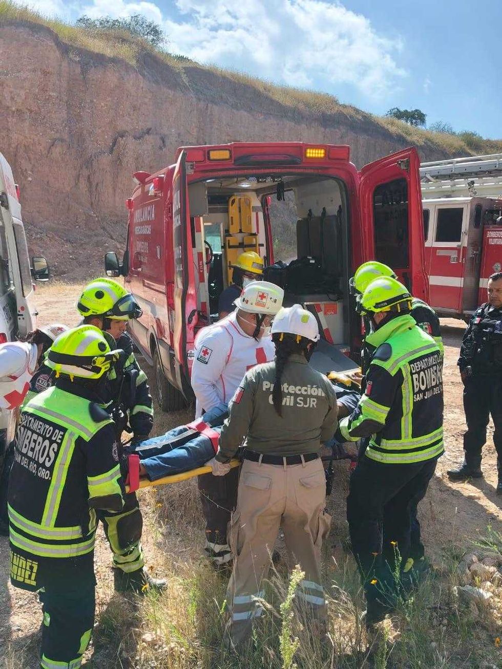 Personal de Bomberos, Cruz Roja y Protecci\u00f3n Civil de San Juan del R\u00edo atiende a una persona en camilla tras la volcadura de una camioneta en el banco de tepetate.