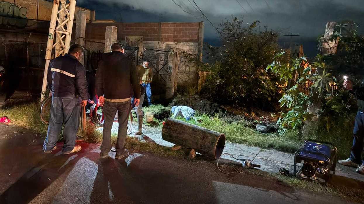 Personal de JAPAM trabaja de noche junto a una excavación y un tubo de gran diámetro en el predio de avenida Río Moctezuma, en San Juan del Río