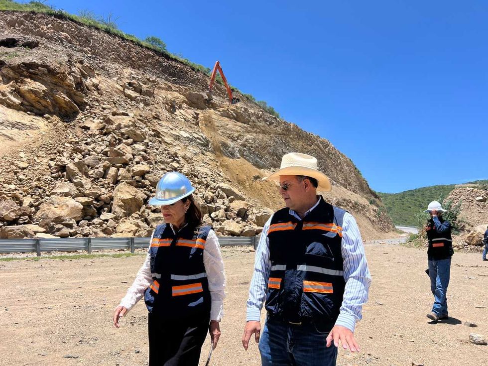 Personal de la Comisi\u00f3n Estatal de Infraestructura observa el talud derrumbado junto a un cargador frontal sobre la Carretera Estatal 100.