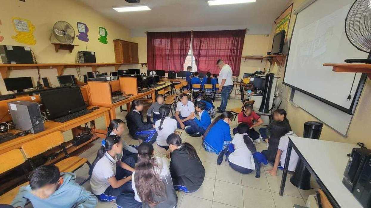 Personal de la Fiscalía de Michoacán imparte una plática sobre acoso escolar a estudiantes en un aula de primaria en Morelia