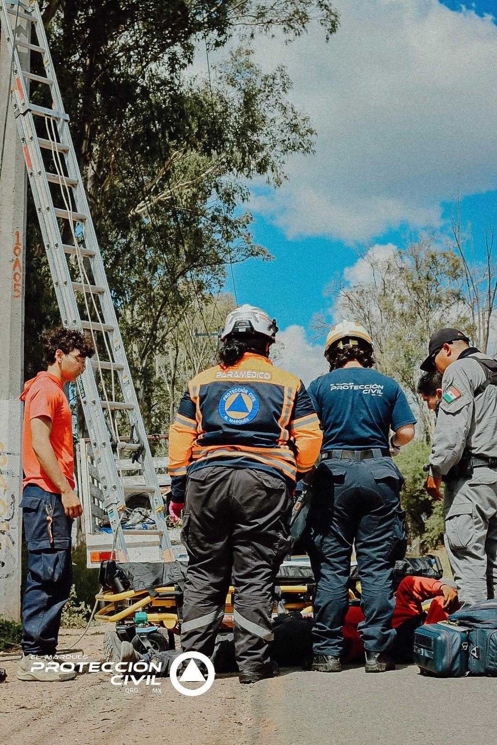 Personal de Protecci\u00f3n Civil El Marqu\u00e9s junto a una escalera en el lugar de la ca\u00edda del trabajador, en Guadalupe La Venta.