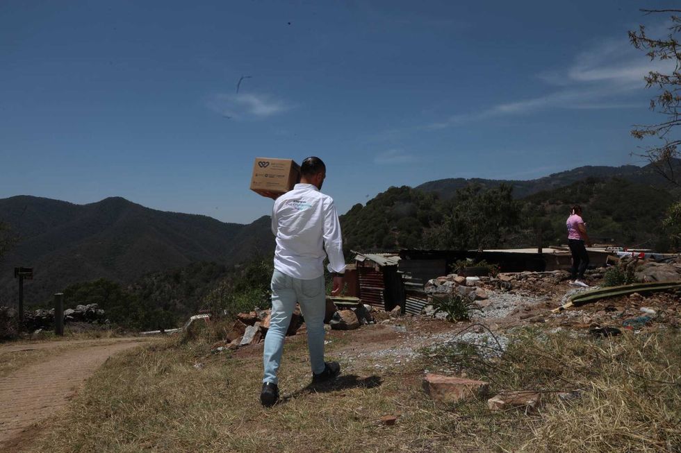 Personal del DIF Estatal Quer\u00e9taro entrega una despensa a una beneficiaria en su domicilio