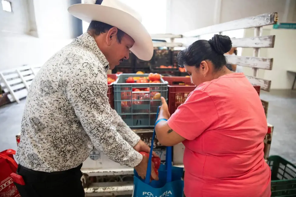 Personal municipal apoya a vecina de La Llave con la entrega de jitomate en jornada de servicios en San Juan del R\u00edo