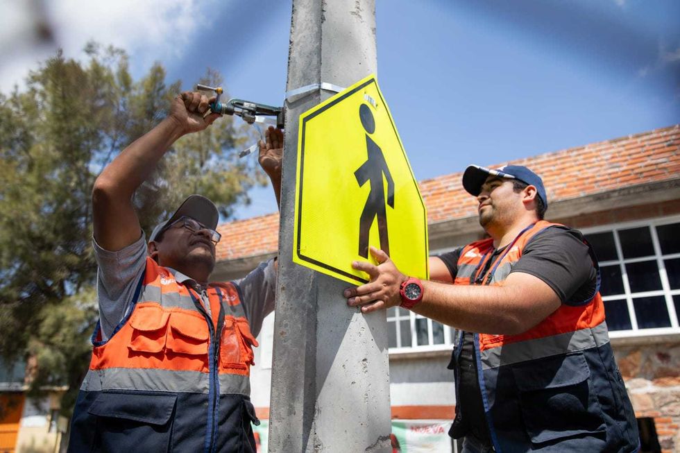 Personal municipal coloca el letrero de la calle Rosa de Castilla durante la jornada de obras del programa comunitario en San Juan del R\u00edo
