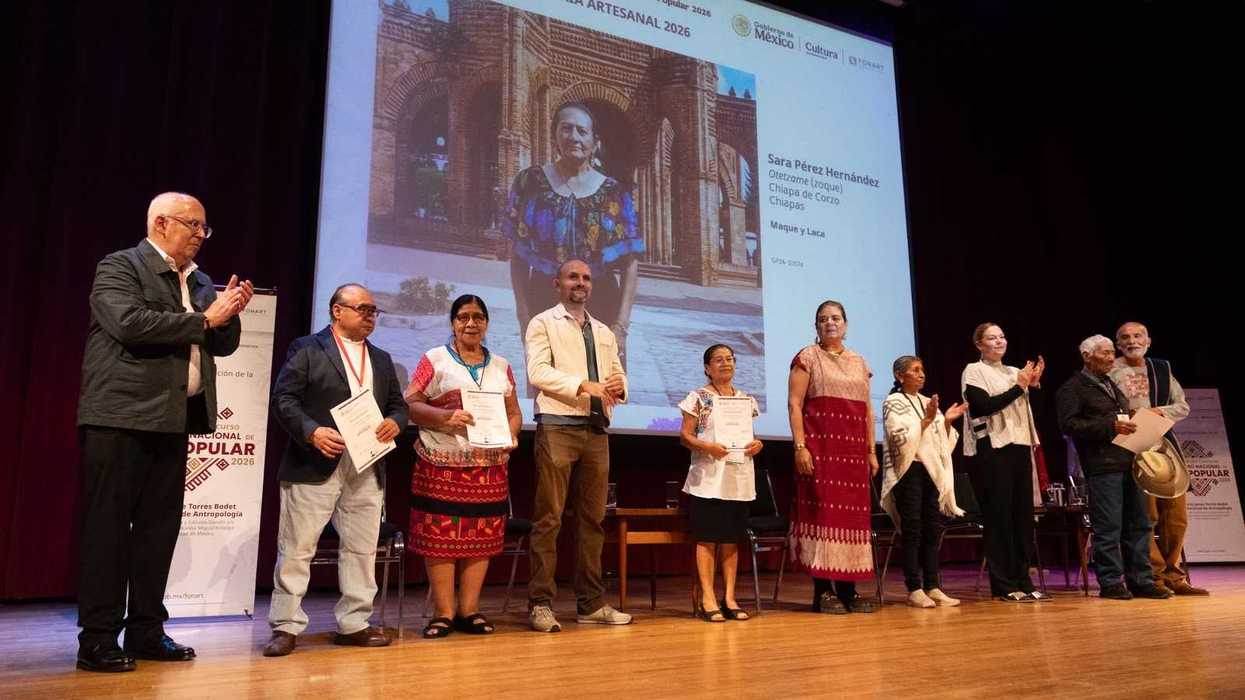 Personas galardonadas sostienen sus diplomas en el escenario del Gran Premio Nacional de Arte Popular 2026