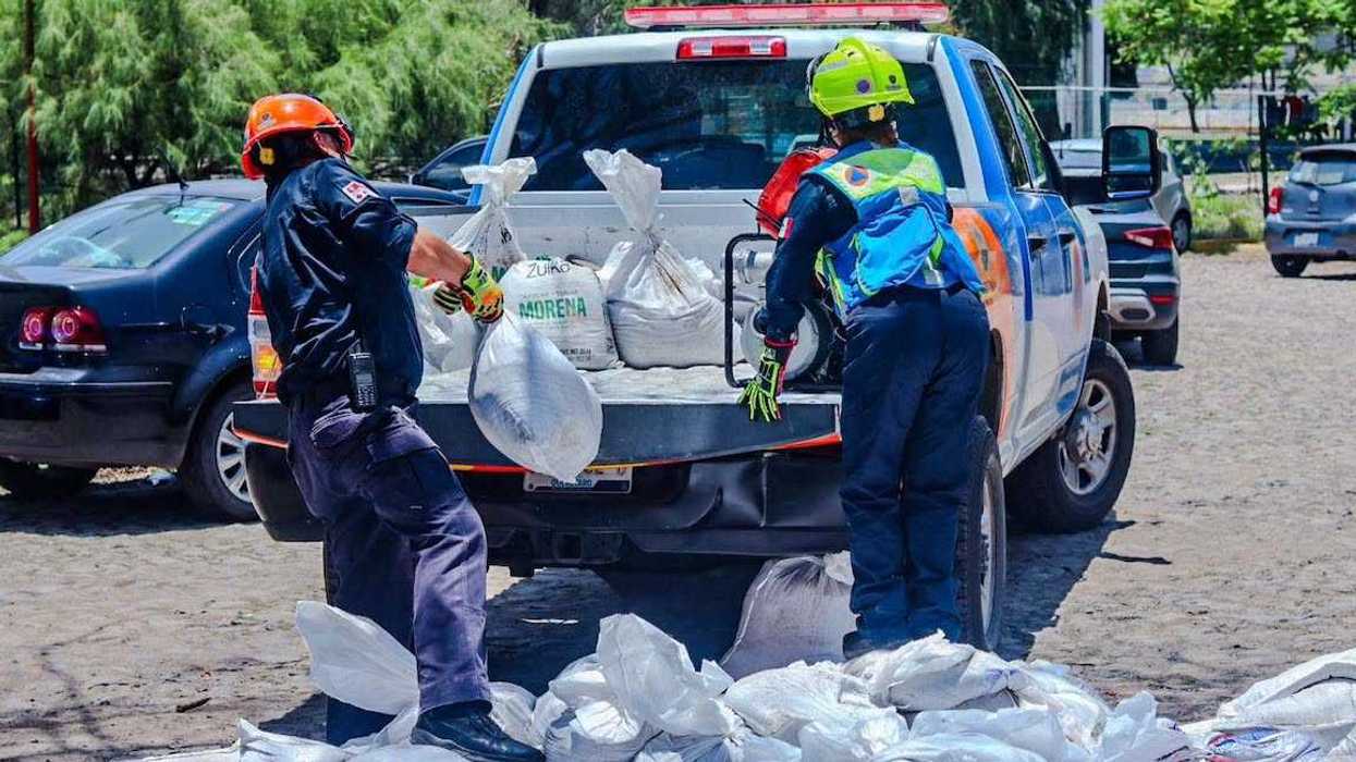 Personas llenan costales con arena en un punto del sistema penitenciario de Querétaro como apoyo al operativo de temporada de lluvias.