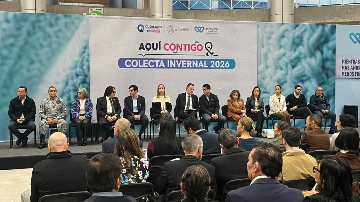 Personas sentadas en el estrado ante la mampara de la Colecta Invernal 2026 del DIF Estatal, con público en primer plano