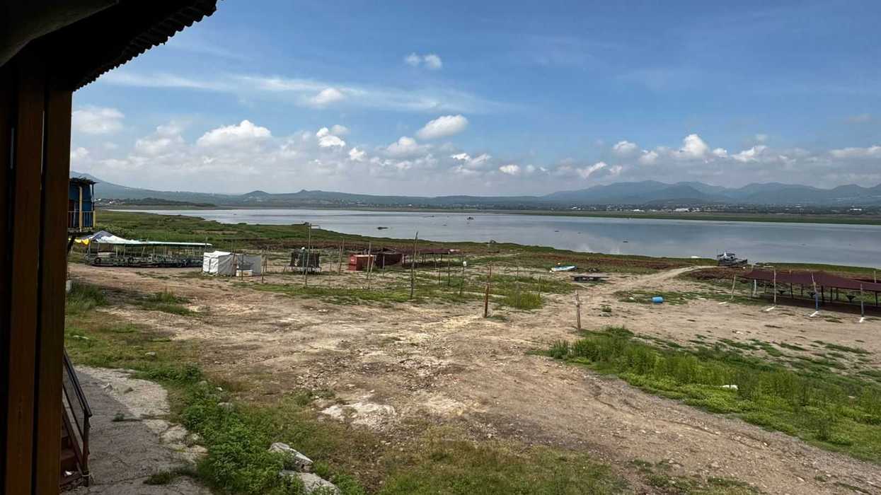 Pescadores de la comunidad de La Estancia realizan labores en la presa afectada por la acumulación de lirio acuático, en San Juan del Río.