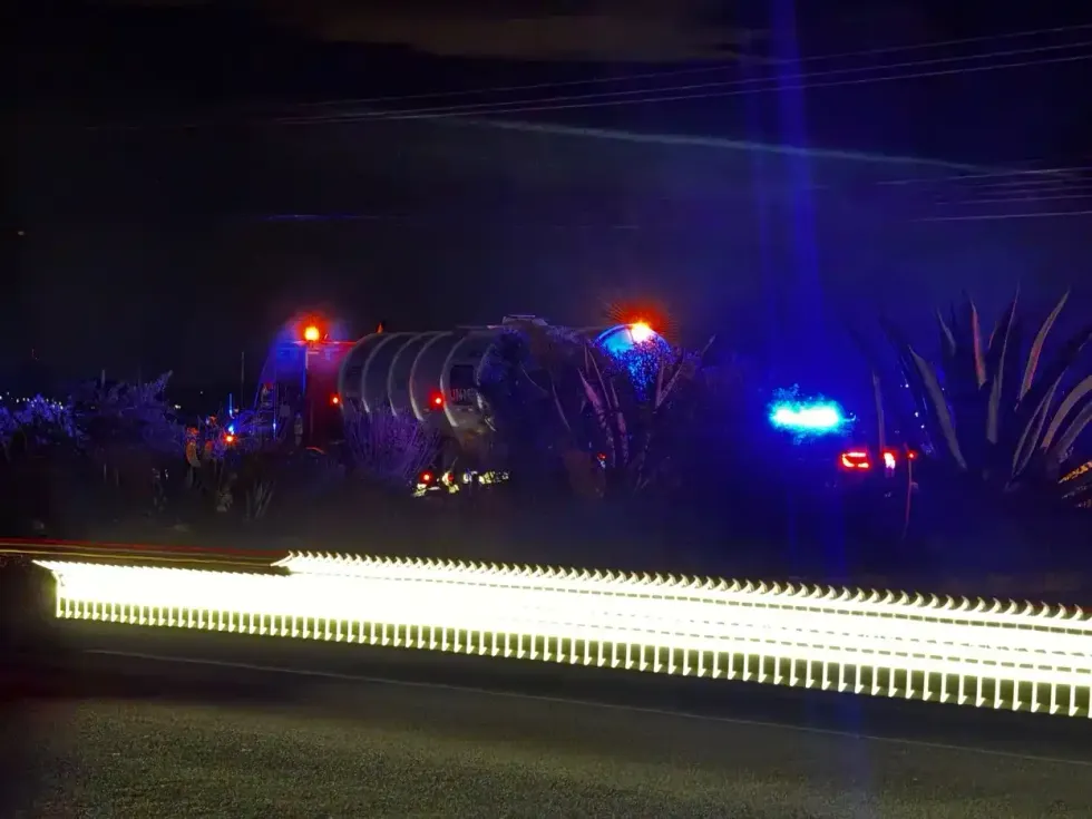 Pipa cisterna detenida entre vegetaci\u00f3n semi\u00e1rida, rodeada de luces de emergencia azules y naranjas de patrullas, en la carretera Federal 45 en los l\u00edmites de Quer\u00e9taro e Hidalgo.
