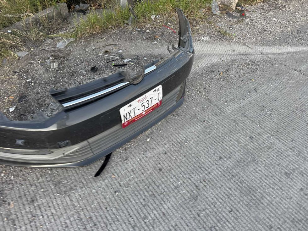 Placa delantera del veh\u00edculo accidentado, desprendida sobre la cinta asf\u00e1ltica de la autopista M\u00e9xico-Quer\u00e9taro.