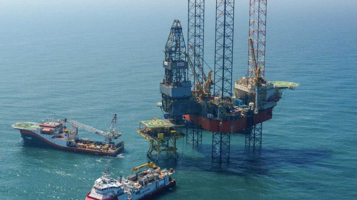 Plataforma petrolera marina acompañada por embarcaciones de apoyo durante operaciones de extracción de hidrocarburos.