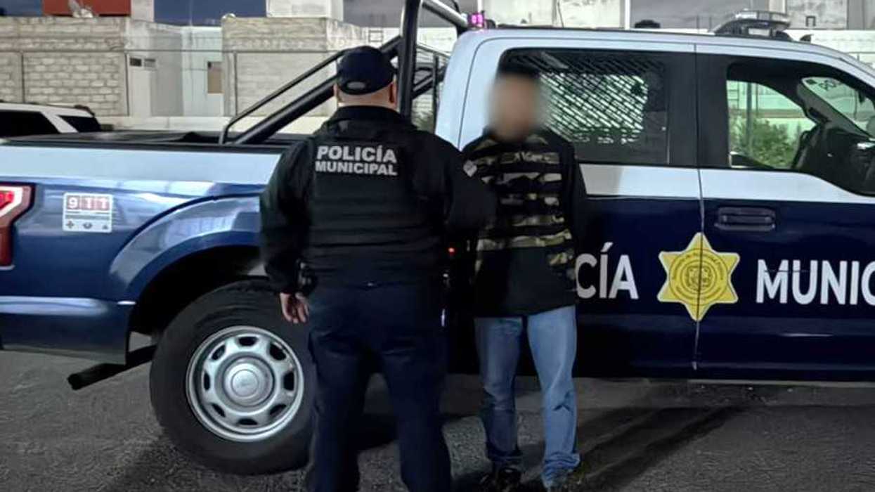 Policía municipal de espaldas junto a hombre detenido por robo simple en Querétaro, frente a patrulla