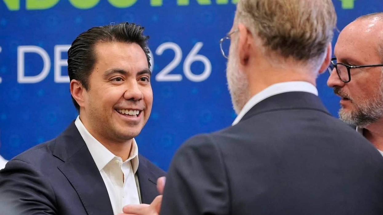 Político sonríe mientras conversa con asistentes durante un evento de la industria en Querétaro