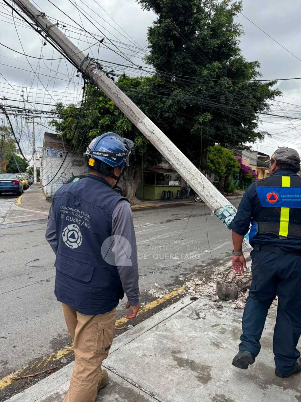 Poste derribado y cables de media tensi\u00f3n ca\u00eddos sobre una calle de la colonia Residencial Galindas en Quer\u00e9taro.