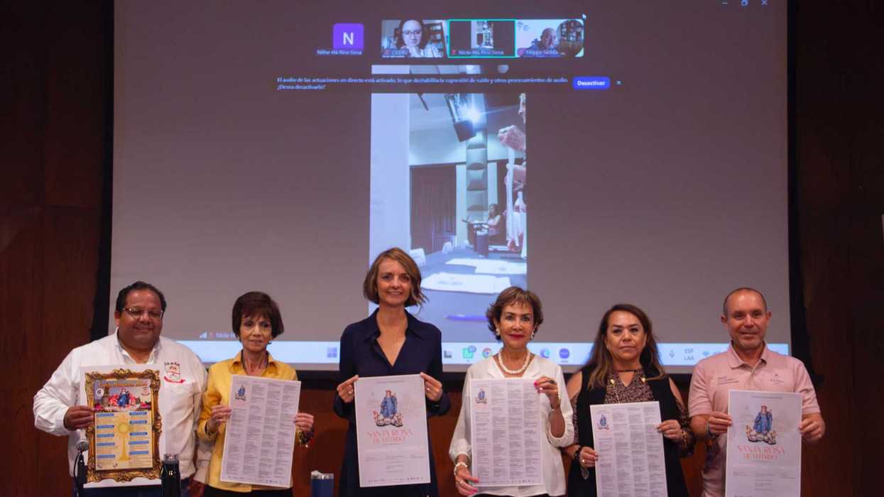 Presentación del Congreso Internacional Santa Rosa de Viterbo en Querétaro; funcionarios y organizadores sostienen el programa del evento frente a una pantalla de videoconferencia con participantes de Italia.