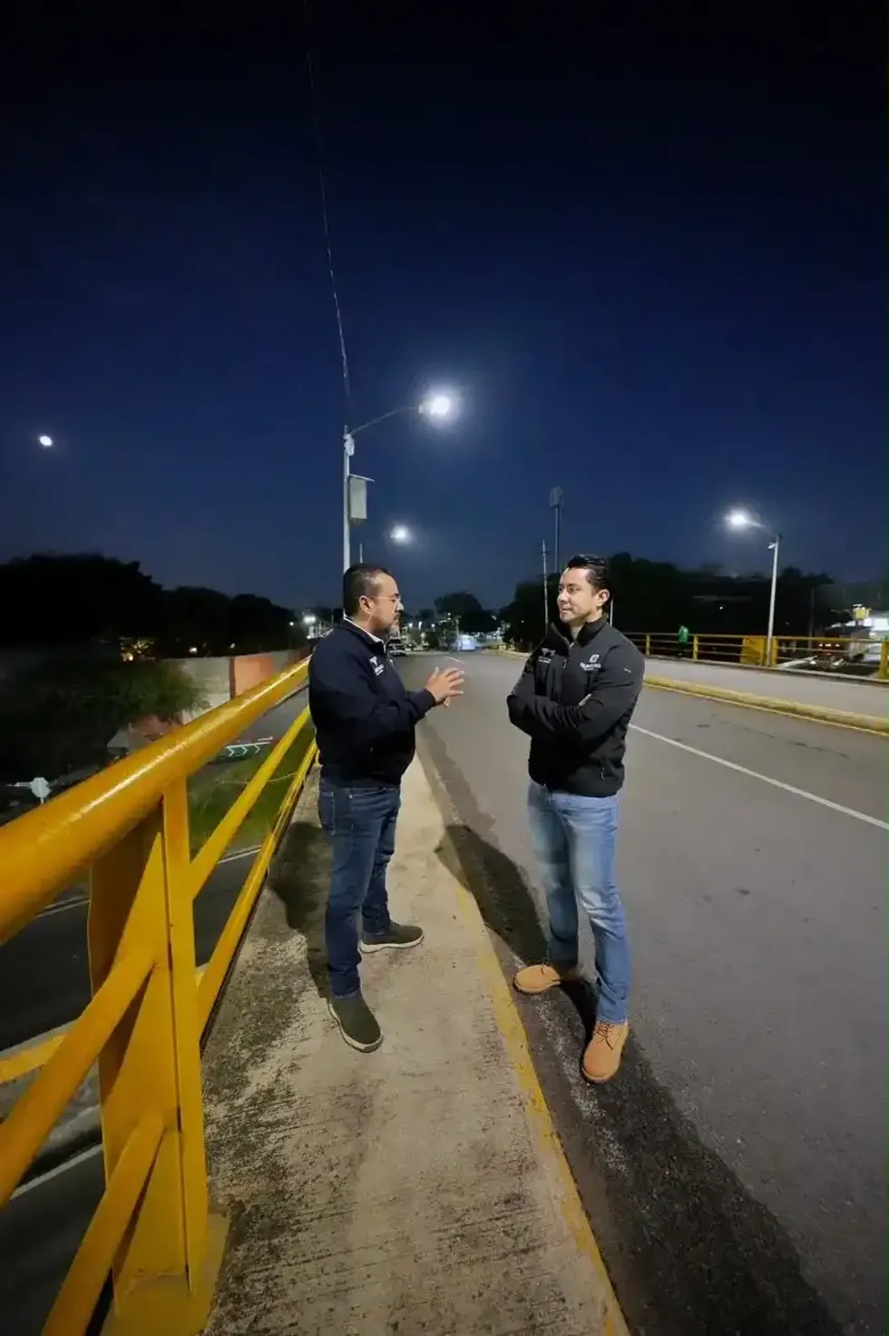 Presidente municipal Felifer Mac\u00edas conversa con un funcionario sobre el puente de Bernardo Quintana durante la supervisi\u00f3n nocturna del operativo vial del Tren M\u00e9xico-Quer\u00e9taro