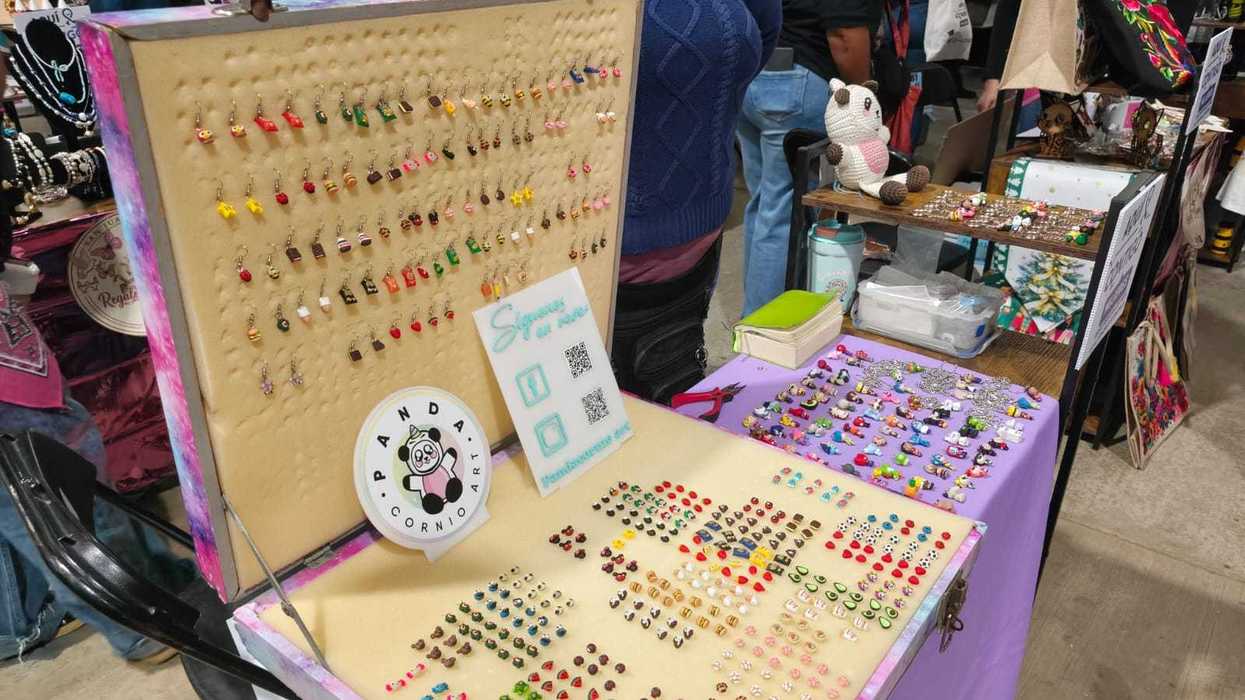 Primer plano de aretes artesanales en miniatura exhibidos en un puesto de la feria de mujeres en San Juan del Río