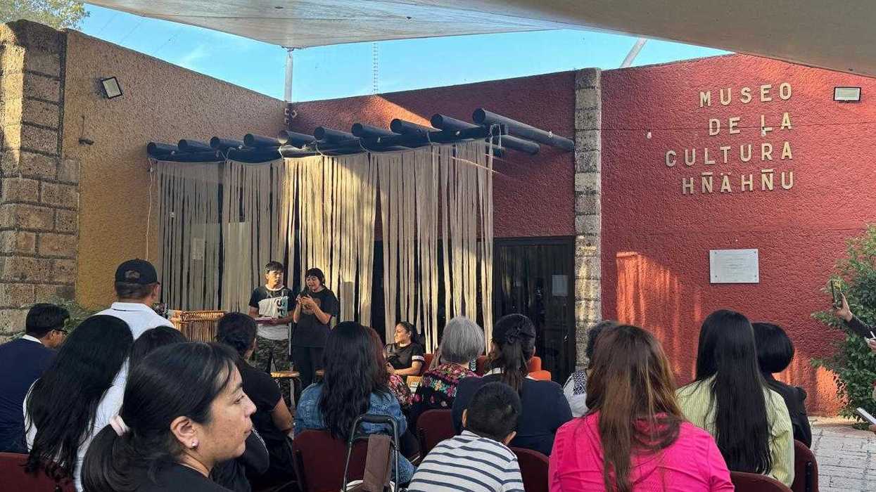 Público frente a dos jóvenes que hablan en una actividad de creación escénica hñähñu en el Museo de la Cultura Hñähñu