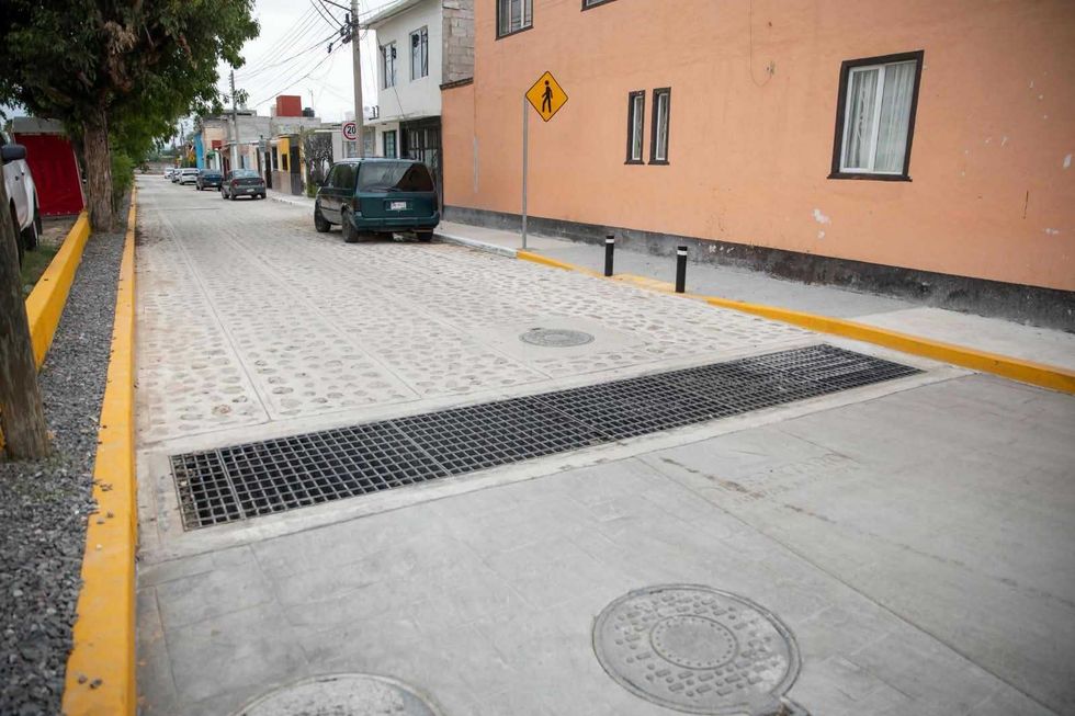 Rejilla del colector pluvial y tapas de pozo sobre la calle urbanizada en Infonavit San Isidro, San Juan del R\u00edo