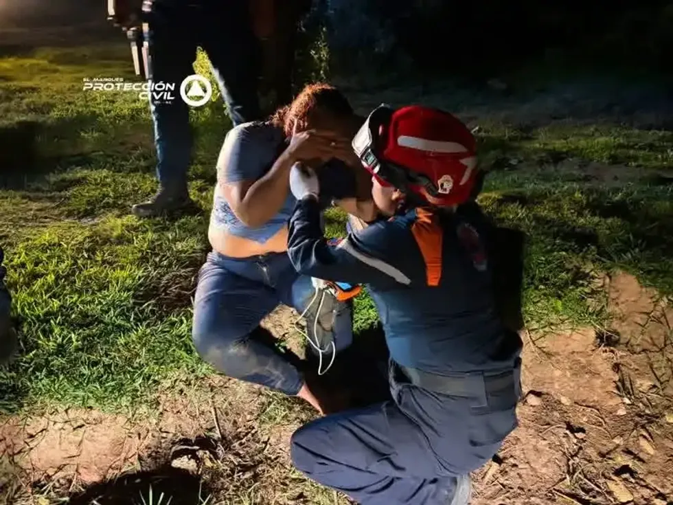 Rescatista de Protecci\u00f3n Civil El Marqu\u00e9s atiende a una de las dos personas rescatadas tras caer un veh\u00edculo a la presa del Carmen durante la noche del 20 de julio de 2026.
